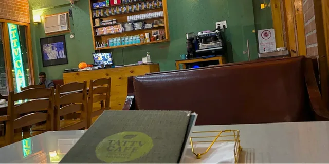 Green walls, wooden tables and a coffee counter inside Tattv Cafe